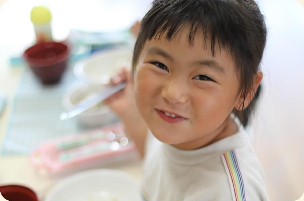 写真：食事中の園児の笑顔