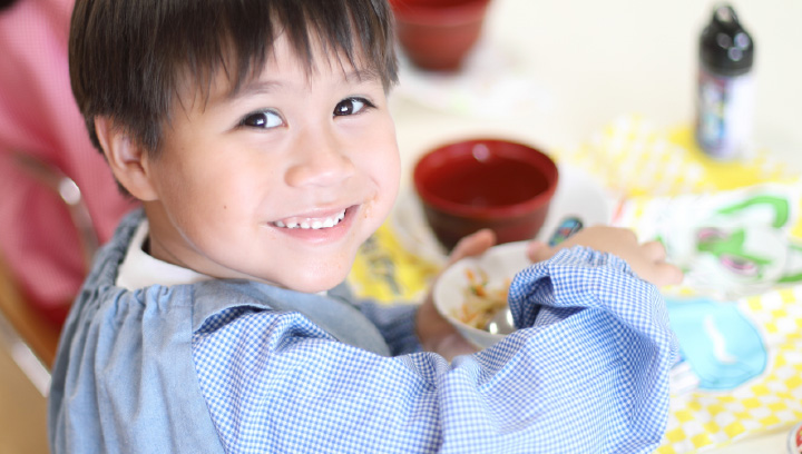 写真：給食を笑顔で食べている園児